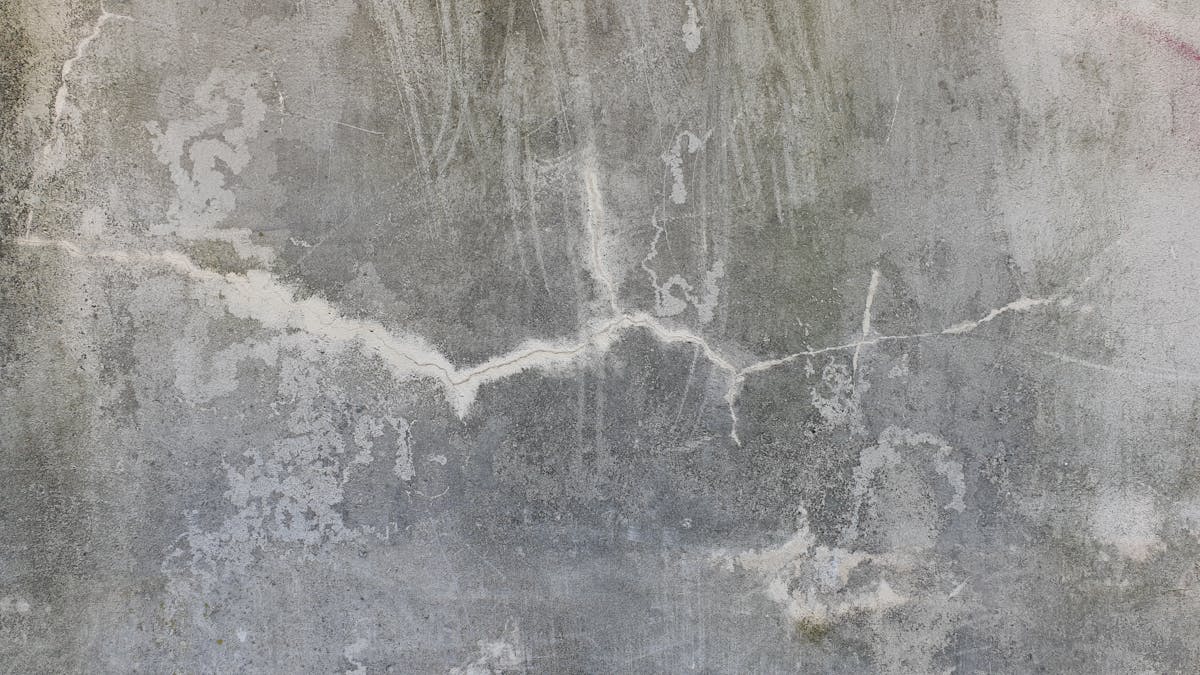 Cracked and weathered concrete slab surface needing repair before epoxy coating