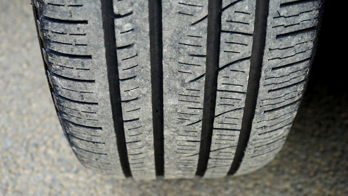 Close-up of car tire tread showing the rubber contact that causes hot tire pickup