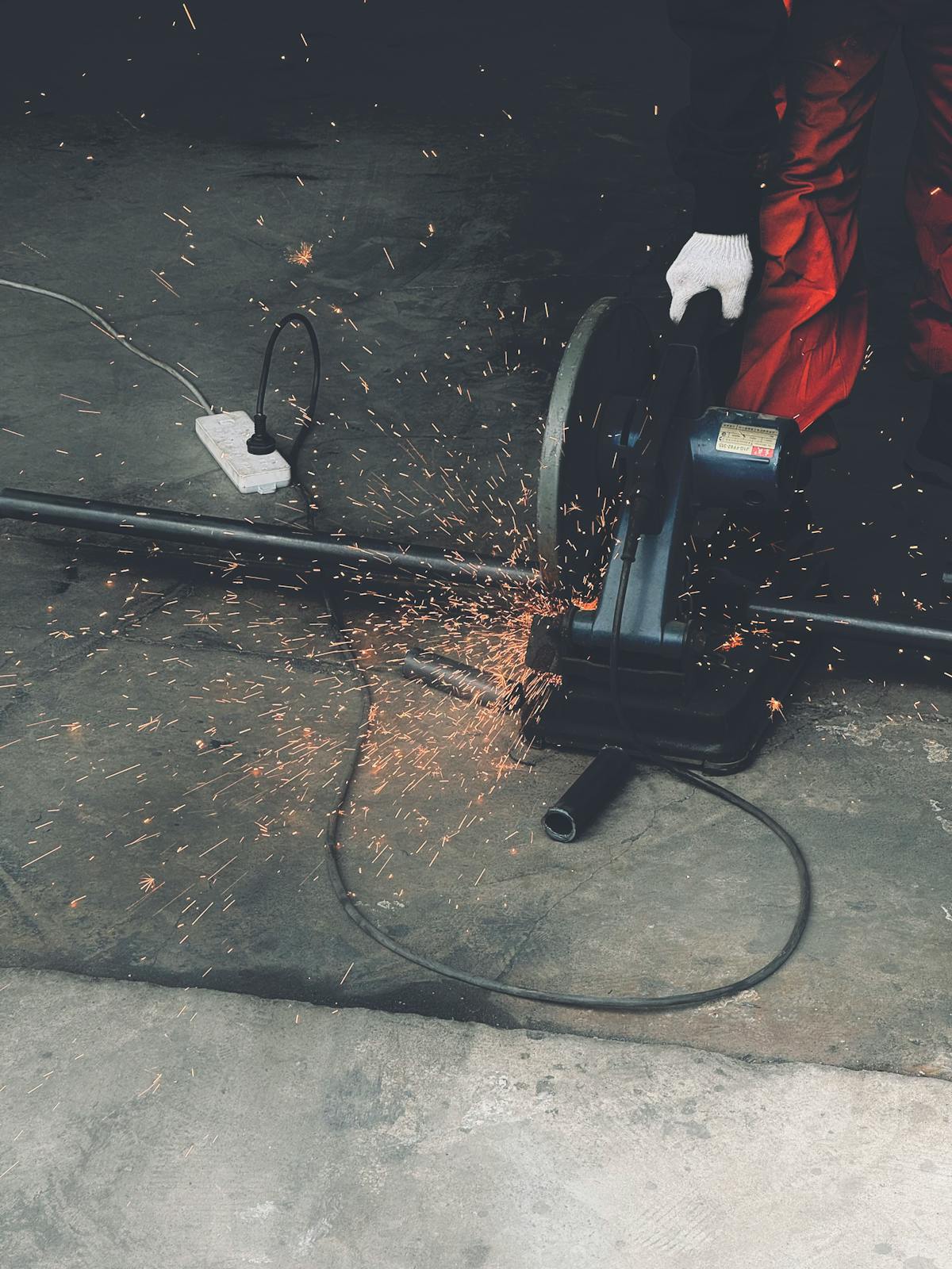 Worker using an angle grinder on concrete floor during slab preparation for epoxy coating